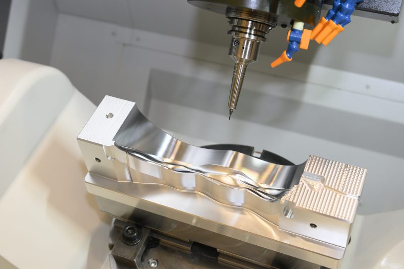 The  5 axis CNC milling machine cutting the  automotive mold parts with solid ball endmill tools. The hi-technology automotive part manufacturing process by 5 axis machining center.